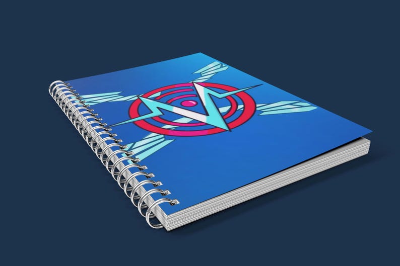 May include: A spiral-bound notebook with a blue cover featuring a graphic design of a red and blue circle with a lightning bolt and wings. The notebook is on a dark blue surface.