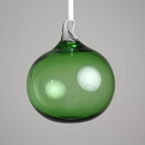 transparent emerald green blown glass ornament with a clear hoop.