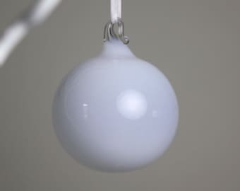 translucent white blown glass ornament with a clear hoop.