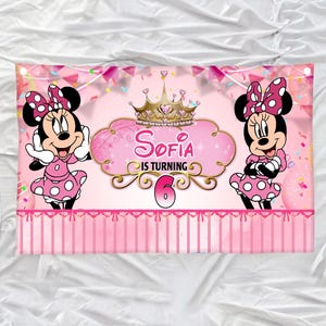 May include: Pink banner featuring Minnie Mouse on either side of a central design. The design includes a gold crown, the name "Sofia", and the phrase "IS TURNING 6". Minnie Mouse is wearing a pink dress with white polka dots and a matching bow.