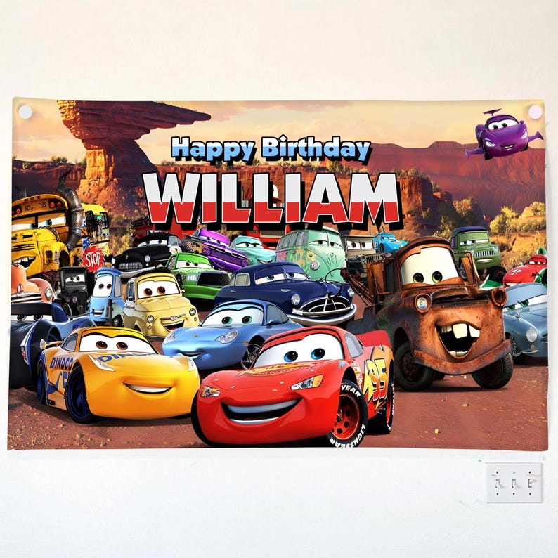 May include: A banner featuring the text "Happy Birthday WILLIAM" with a background of cartoon cars. The banner includes images of various animated cars, including Lightning McQueen and Mater, set against a desert landscape.