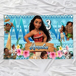 May include: A rectangular banner featuring a blue patterned background with Moana characters, the number 3, and a wooden sign with the name Amelia printed in blue script. The design includes tropical flowers, green leaves, and a small pig character.