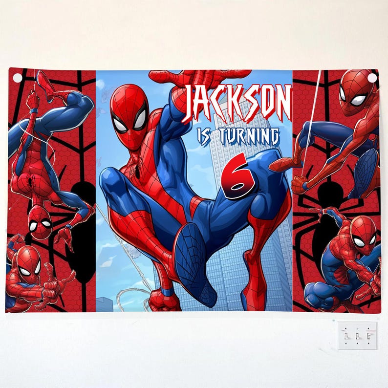 Pu&ograve; includere: Uno striscione rettangolare con Spider-Man in varie pose d'azione su uno sfondo rosso e blu. Il testo recita "JACKSON IS TURNING 6" con un carattere stilizzato. Il design include lo skyline di una citt&agrave; e motivi a ragnatela.