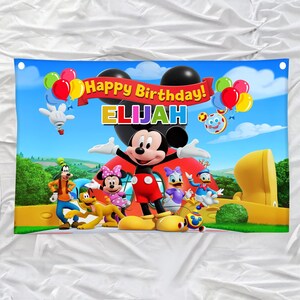 Pu&ograve; includere: Un banner colorato con Topolino e i suoi amici, con la scritta "Happy Birthday! ELIJAH". Il design include palloncini e un paesaggio a cartoni animati, ideale per una festa di compleanno.