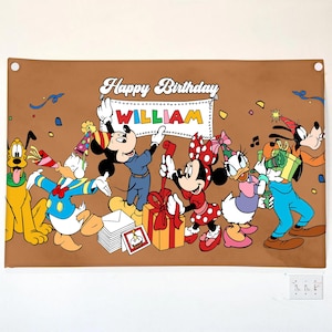 K&ouml;nnte beinhalten: Ein braunes Banner mit Disney-Figuren, die einen Geburtstag feiern. Micky Maus, Minnie Maus, Donald Duck, Daisy Duck, Goofy und Pluto sind abgebildet. Auf dem Banner steht "Happy Birthday WILLIAM" in wei&szlig;er Schrift.