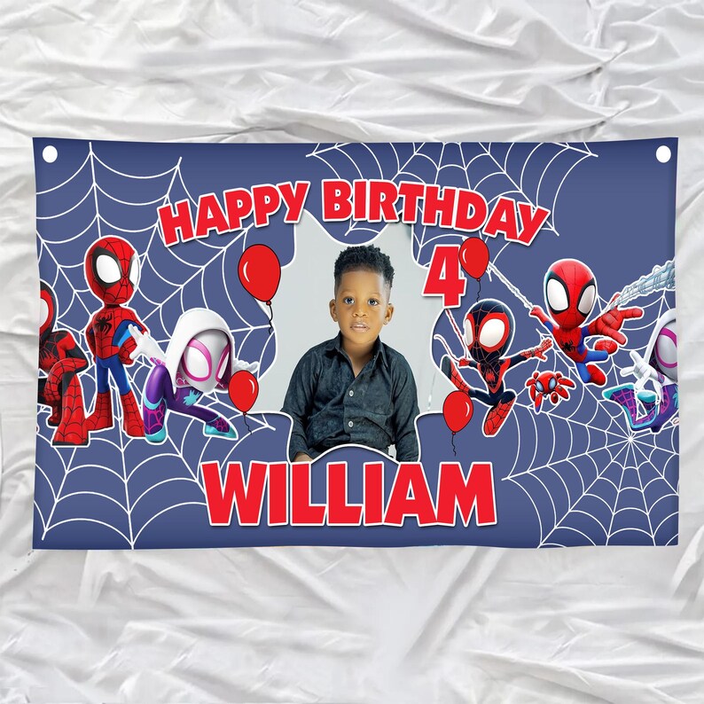 Może przedstawiać: Prostokątny niebieski baner urodzinowy z białym wzorem pajęczyny, czerwonym napisem HAPPY BIRTHDAY, cyfrą 4 i imieniem WILLIAM. Projekt zawiera postacie pająk&oacute;w, czerwone balony oraz centralnie umieszczone zdjęcie dziecka.