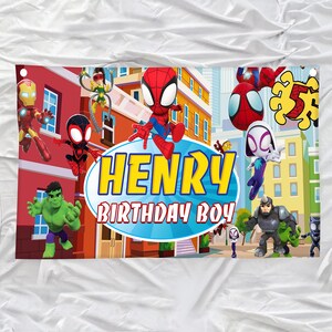 Puede incluir: Una pancarta de cumplea&ntilde;os rectangular con un fondo de ciudad colorido y personajes de dibujos animados que incluyen a Spider-Man, Hulk e Iron Man. El centro muestra un &oacute;valo azul con el texto amarillo HENRY y el texto blanco BIRTHDAY BOY.