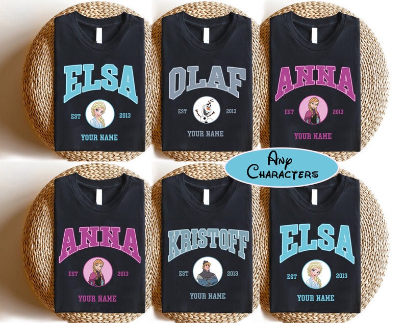 Puede incluir: Camisetas negras con nombres de personajes en texto arqueado. Cada camiseta presenta un nombre diferente: Elsa, Olaf, Anna y Kristoff. Cada dise&ntilde;o incluye una imagen del personaje, el a&ntilde;o 2013 y el texto "Your Name". Tambi&eacute;n est&aacute; presente el texto "Any Characters".