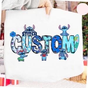 May include: White tote bag featuring the word "CUSTOM" in blue, floral-patterned letters, with the word "STITCH" above it. The design includes cartoon Stitch characters and tropical elements.