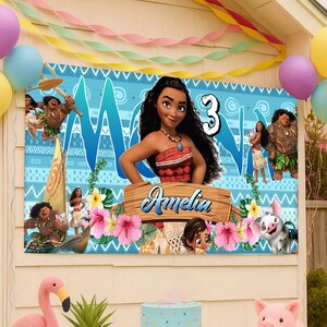 May include: A rectangular party banner featuring Moana characters, a large number 3, and a wooden sign with the name Amelia printed in blue script. The background is light blue with tribal patterns, pink hibiscus flowers, and green leaves.