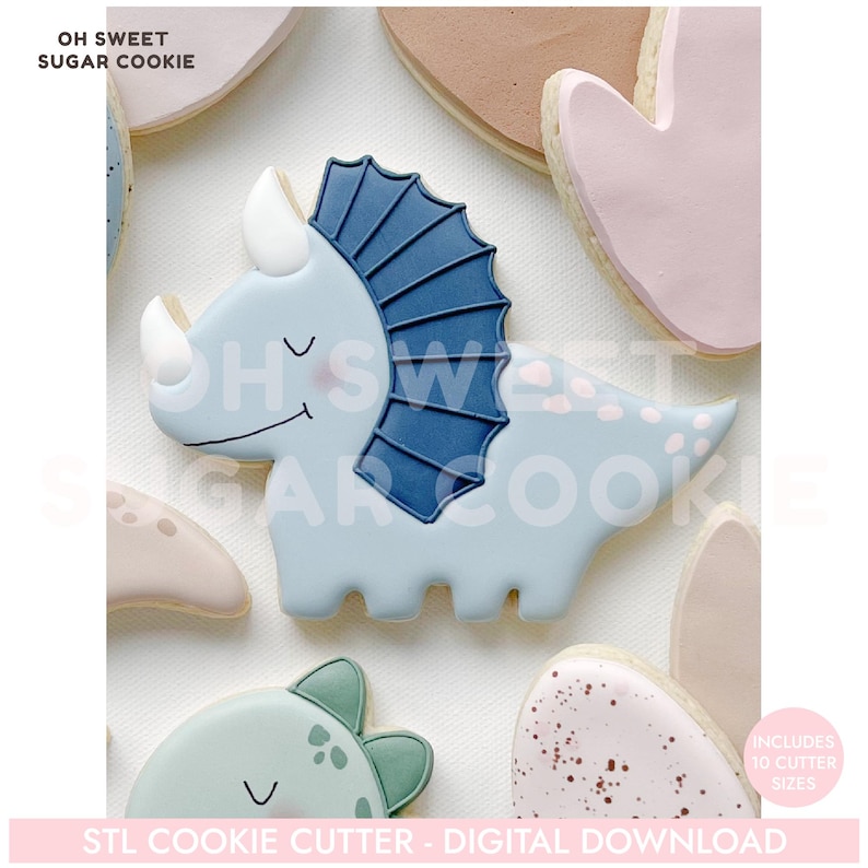 May include: A light blue triceratops cookie with a dark blue frill and white horns. The cookie is surrounded by other dinosaur-shaped cookies in various pastel colors. Text on the image reads "OH SWEET SUGAR COOKIE" and "STL COOKIE CUTTER - DIGITAL DOWNLOAD".