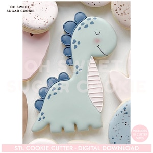 K&ouml;nnte beinhalten: Hellblauer Dinosaurier-Ausstecher mit einem l&auml;chelnden Gesicht, blauen Akzenten und einer rosa Wange. Der Ausstecher ist von anderen dekorierten Keksen umgeben. Der Text auf dem Bild lautet "OH SWEET SUGAR COOKIE" und "STL COOKIE CUTTER - DIGITAL DOWNLOAD."