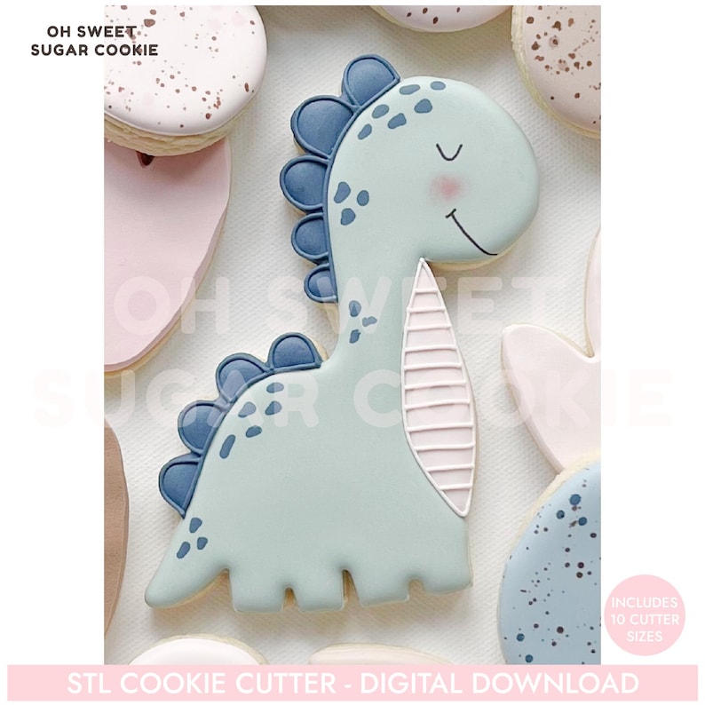 K&ouml;nnte beinhalten: Hellblauer Dinosaurier-Ausstecher mit einem l&auml;chelnden Gesicht, blauen Akzenten und einer rosa Wange. Der Ausstecher ist von anderen dekorierten Keksen umgeben. Der Text auf dem Bild lautet "OH SWEET SUGAR COOKIE" und "STL COOKIE CUTTER - DIGITAL DOWNLOAD."
