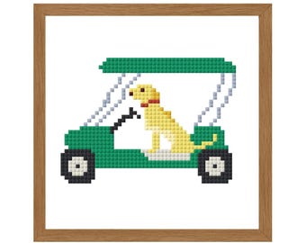 May include: A framed cross-stitch design featuring a yellow dog in a green golf cart. The dog has a red collar. The cart has black wheels and a white roof. The frame is a light brown color.