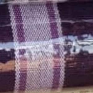 Puede incluir: Una tela textil enrollada apretadamente que presenta un color base morado oscuro con rayas verticales prominentes en tonos blancos y morados m&aacute;s claros. La tela tiene una textura tejida visible y est&aacute; envuelta en un pl&aacute;stico protector transparente.