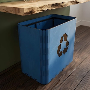May include: A blue wooden recycling bin with a cutout recycling symbol. The bin is rectangular with a slightly curved top and is made of multiple wooden panels. The bin is sitting on a wooden floor.