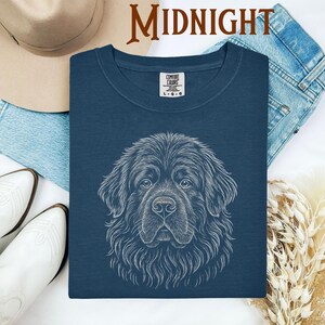 May include: A navy blue Comfort Colors t-shirt featuring a detailed white line drawing of a dog's face. The word "MIDNIGHT" is printed in a brown font at the top. The shirt is surrounded by a hat, jeans, and boots.