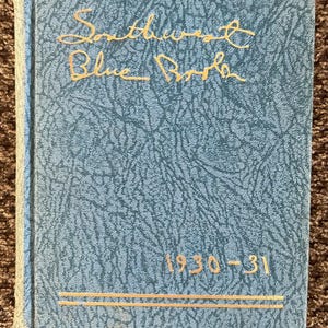 May include: A vintage book titled "Southwest Blue Book" from 1930-31. The cover is a textured, light blue with gold lettering and accents. The book's title is in an elegant script, and the year is displayed in a simple, classic font.