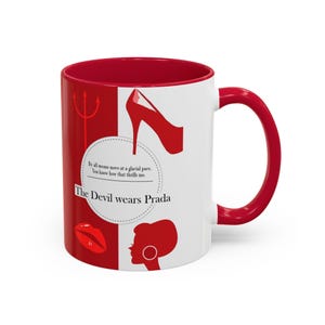 Puede incluir: Una taza de cerámica blanca con interior y asa rojos. La taza presenta ilustraciones rojas de un tacón alto, labios y la silueta de una mujer. El texto en la taza dice "The Devil wears Prada" con una cita sobre el ritmo glacial.