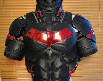 May include: Black and red superhero chest armour with a high collar and shoulder pads. The armour features a carbon fibre texture with red accents on the chest and shoulders. The chest plate has a stylized design.