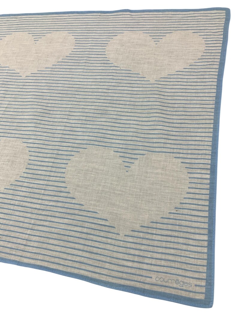K&ouml;nnte beinhalten: Blau-wei&szlig;es Tuch mit Herzmuster. Der Schal hat horizontale blaue Streifen und gro&szlig;e wei&szlig;e Herzformen. Die Kanten sind mit einem durchgehenden blauen Rand versehen. Der Markenname "courr&egrave;ges" ist unten rechts aufgedruckt.