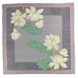 May include: Square scarf with a floral lotus design. The scarf features a light purple background with a darker purple border and a pink inner border. The lotus flowers are cream-colored with pink accents, and the leaves are green.