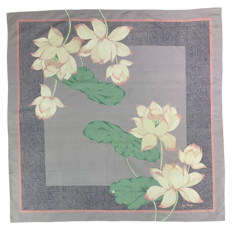 May include: Square scarf with a floral lotus design. The scarf features a light purple background with a darker purple border and a pink inner border. The lotus flowers are cream-colored with pink accents, and the leaves are green.