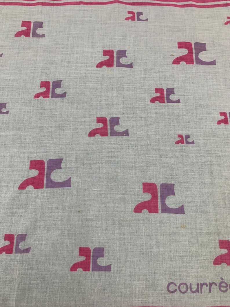 Peut inclure: Un tissu gris clair avec un motif r&eacute;p&eacute;t&eacute; de logos "AC" stylis&eacute;s en rose et violet. Le mot "courr&egrave;ges" est imprim&eacute; en rose en bas &agrave; droite. Une bande rose longe le bord sup&eacute;rieur.