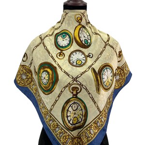 May include: Cream-coloured square scarf with a repeating pattern of gold-framed pocket watches and chain links. The scarf has a dark blue border and decorative floral accents. A vintage accessory.