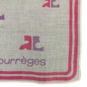 Peut inclure: Un textile gris clair avec un logo rose et violet et le mot "courr&egrave;ges" en violet. La bordure pr&eacute;sente deux rayures roses. Le logo est r&eacute;p&eacute;t&eacute; sur le tissu.