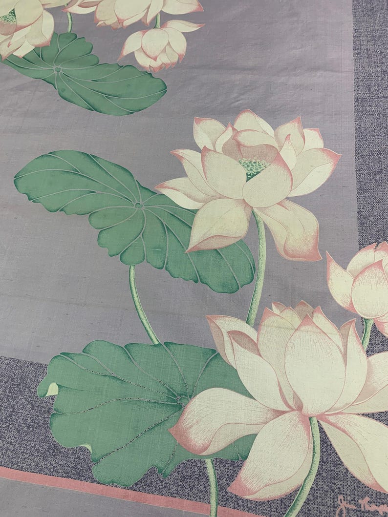 May include: A floral textile featuring a repeating pattern of lotus flowers and leaves. The flowers are white with pink edges, and the leaves are green. The background is a muted purple with a textured appearance, and a pink stripe runs along the bottom.