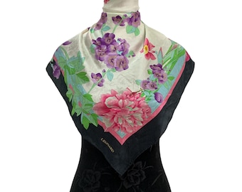 May include: A square silk scarf with a floral design. The scarf features a large pink peony, purple flowers, and green leaves against a cream background. The border is black with a pink and blue accent. The brand name "LEONARD" is visible.