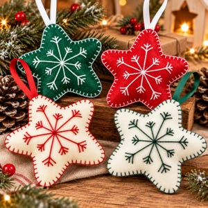 May include: Four star-shaped felt ornaments with embroidered snowflake patterns. One is dark green with white stitching, one is red with white stitching, one is cream with red stitching, and one is cream with dark green stitching, each with a ribbon loop.