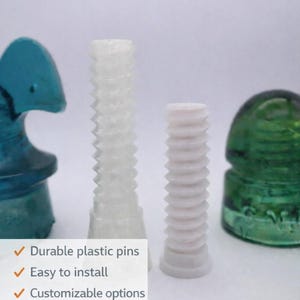 May include: Image of 3D printed insulator pins. The image shows two white, threaded pins and two glass insulators in blue and green. Text on the image says "Durable plastic pins", "Easy to install", and "Customizable options".