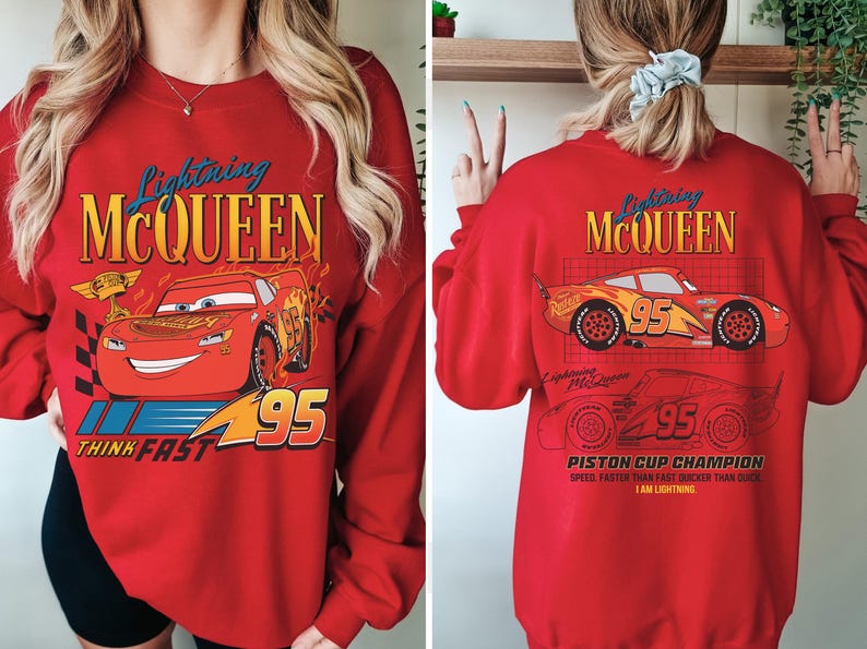 May include: Red sweatshirt featuring Lightning McQueen from the Cars movie. The front graphic shows McQueen with the number 95 and the text "THINK FAST". The back displays McQueen's image and the text "PISTON CUP CHAMPION".