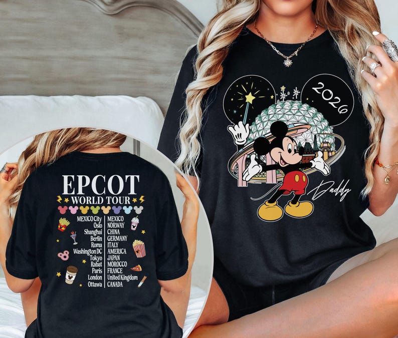 May include: Black t-shirt featuring Mickey Mouse in front of a Spaceship Earth design, with the text "2026" and "Daddy". The back of the shirt displays "EPCOT WORLD TOUR" with various city names and icons.