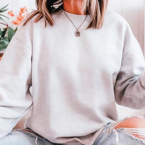 The Gildan 18000 offers everyday comfort with style. Blank sweatshirt for daily wear, lounge looks, or layering. Soft fleece interior, classic crewneck fit, and print-friendly exterior. Customize it for Etsy, Shopify, or personal use. A customer favorite for soft feel and print clarity.
