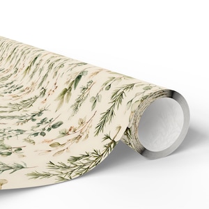 May include: A roll of wrapping paper featuring a cream-colored background with a repeating watercolor pattern of various green herbs, including rosemary sprigs, eucalyptus leaves, and thin botanical stems scattered across the surface.