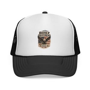 May include: A white and black trucker cap featuring a central graphic of a bald eagle with wings spread over a distressed American flag background. The text BUILT DIFFERENT is printed above the eagle, and SINCE 1776 is printed below the eagle.