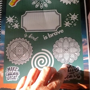 May include: A spiral-bound notebook with a green cover. It features floral designs and the phrases "You are Awesome!", "Make Today Great", and "Live and Learn". The words "is kind is brave" are also visible.