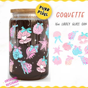 May include: A glass can wrap with a seashell design. The wrap features pink, blue, and white seashells with bows. The text "COQUETTE SEASHELLS" is displayed. The wrap is designed for a 16oz Libbey glass can and measures 9.75" x 5".