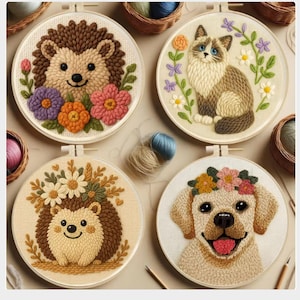 May include: Four embroidered hoops with animal and floral designs. The designs include a hedgehog with flowers, a cat surrounded by flowers, a hedgehog with daisies, and a dog with a flower crown. The hoops are set against a neutral background.
