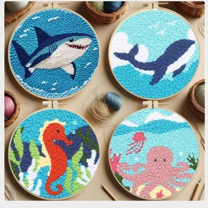 May include: Four round, framed punch needle art pieces featuring marine life. Designs include a shark, whale, seahorse, and octopus, each set against a blue background. The art is displayed in wooden embroidery hoops, showcasing a handmade craft.