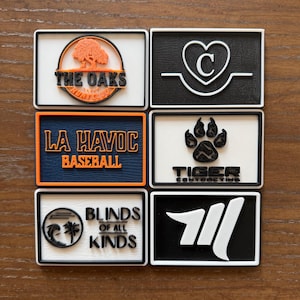 May include: Six rectangular patches with raised designs. Top left: The Oaks Hunt Club with an orange tree. Top right: A heart with a C. Middle left: La Havoc Baseball in orange on navy. Middle right: Tiger Contracting with a paw print. Bottom left: Blinds of All Kinds with a wave and palm tree. Bottom right: A white abstract logo on black.