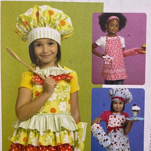 May include: McCall's Fashion Accessories sewing pattern M6049 for children's aprons, chef hats, and oven mitts. The envelope displays three variations of kitchen attire featuring floral, polka dot, and cupcake patterns in bright colors.