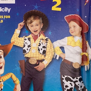 Op de afbeelding: Een Simplicity naaipatroon-envelop voor Toy Story 2 kinderkostuums, model 9433, maat A 3,4,5,6,7,8. De blauwe verpakking bevat illustraties van Woody en Jessie naast een kind dat een geel geruit overhemd en een vest met koeienprint draagt.