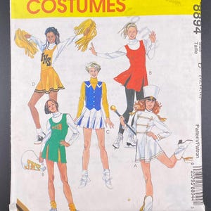 May include: A vintage McCall's Costumes pattern envelope. The yellow cover features illustrations of cheerleaders and a majorette in various outfits. The text includes "McCall's Costumes" and the pattern number 8894.