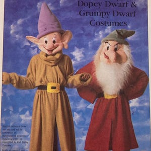 May include: A Simplicity sewing pattern envelope for Walt Disney's Dopey Dwarf and Grumpy Dwarf costumes in size large. The cover features illustrations of two characters wearing long tunics, belts with buckles, and pointed hats.
