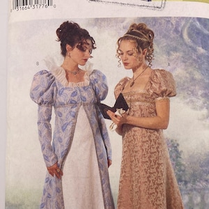 May include: Butterick sewing pattern 6630 for sizes 18-20-22, featuring Making History branding. The envelope displays two floor-length dresses with empire waists, puff sleeves, and square necklines, one in blue with a leaf pattern and one in tan.