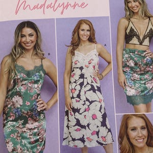 May include: Simplicity sewing pattern S9729 Madalynne for sizes XS-XL. The envelope displays three garment variations: a green floral slip dress with lace trim, a white floral dress with pink accents, and a black lace bralette with a floral skirt.
